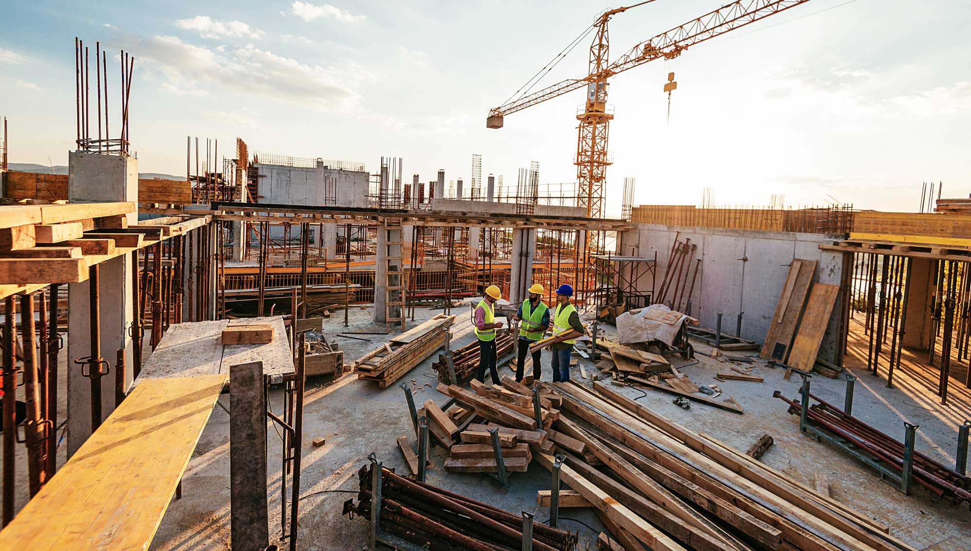 Tre byggarbetare på en byggarbetsplats